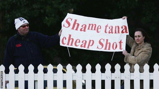 A sign reads: Shame tana cheap shot