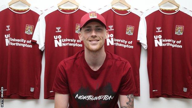 Mitch Pinnock poses in the Northampton changing room