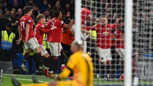 Chelsea keeper Willy Caballero looks on as Manchester United players celebrate