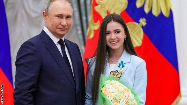 Russian President Vladimir Putin poses with figure skater Kamila Valieva during an awards ceremony for the Beijing 2022 Winter Olympic Games medal winners at the Kremlin in Moscow on April 26