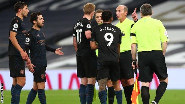 Tottenham players protesting with referee Mike Dean