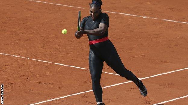 Serena Williams playing tennis in a black catsuit