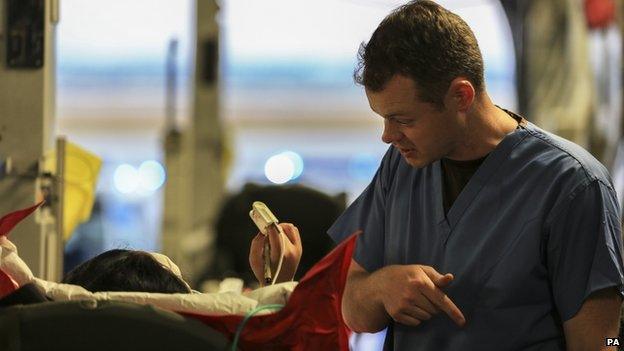 A medic communicates with a patient on an RAF plane