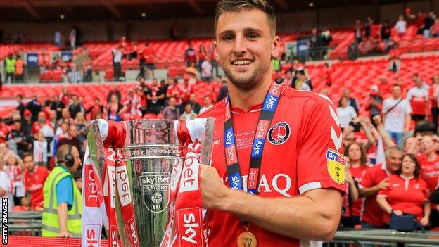 Ben Purrington holds the League One play-off trophy