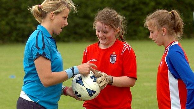 woman talking with two young footballers