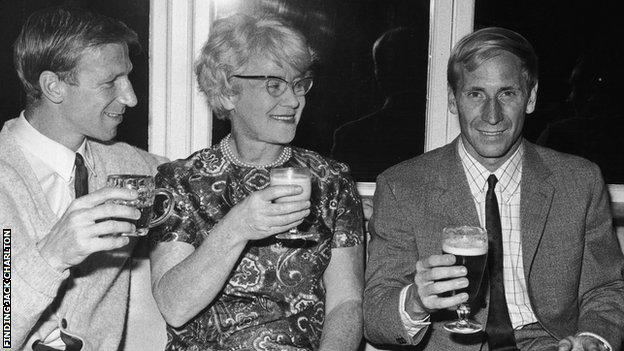 Left to right: Jack Charlton, Cissie Charlton, Bobby Charlton. All holding drinks.