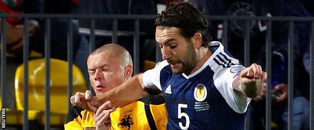 Lithuania's Darvydas Sernas tackles Scotland's Charlie Mulgrew