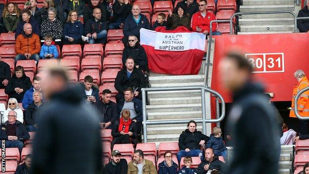 Saints fans hold aloft banner