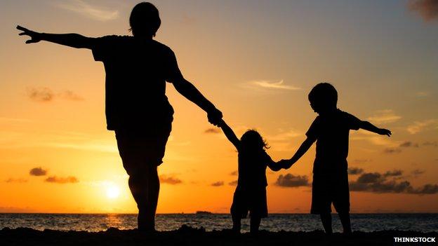 Family walk along a beach at sunset