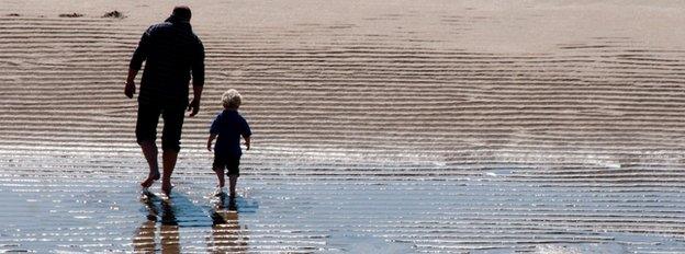 Man and boy walking on beach