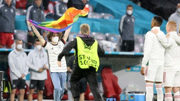 Protestor with rainbow flag ahead of the Germany v Hungary game