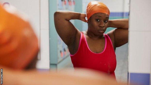 A woman putting on her swimming cap