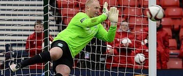 Conrad Logan dives to save Blair Spittal's penalty in the shoot-out