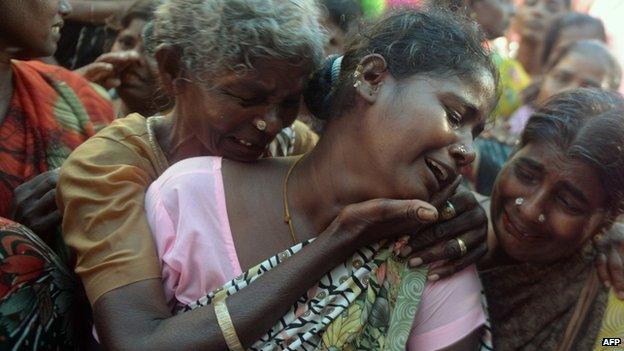 An Indian woman breaks down as she sees the dead body of her family member, a victim of toxic home-made liquor consumption, in Mumbai on 20 June 2015.