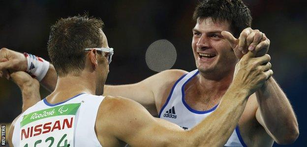 Richard Whitehead hugs teammate Dave Henson after their T42 200m race