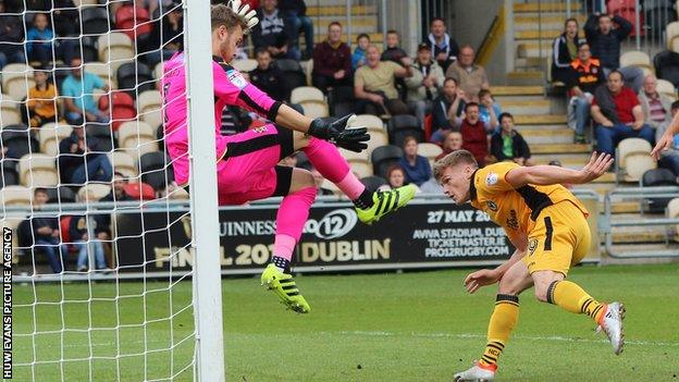 Rhys Healey heads the ball past Cambridge goalkeeper Will Norris