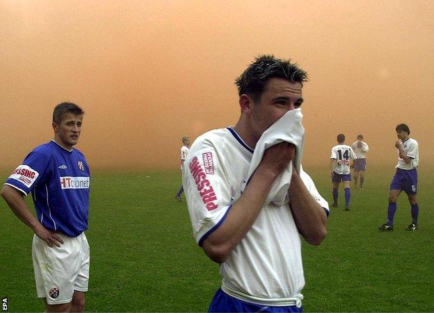 Dario Srna of Hajduk Split covers his face as the Croatian soccer league match between Hajduk Split and Dinamo Zagreb is stopped due to smoke bombs of spectators at the stadium in Split, 07 April 2002. The match continued after a six-minute break.