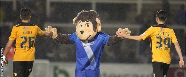 Regan Poole and Aaron Collins high five Hartlepool's monkey mascot