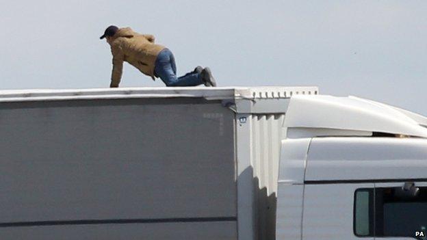 File photo dated 24/06/15 of a migrant trying to board UK bound lorries on the main road into Calais ferry port