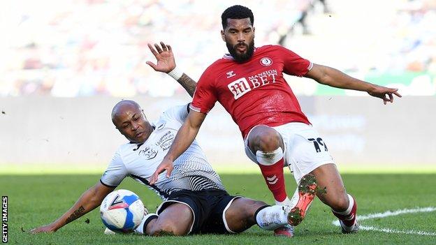 Swansea's Andre Ayew slides in on Adrian Mariappa of Bristol City