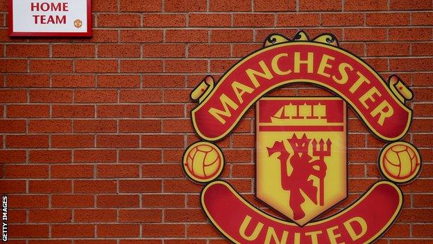 A wall with the Manchester United crest on it outside Old Trafford