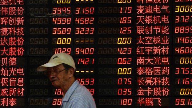 Man walking past stock board