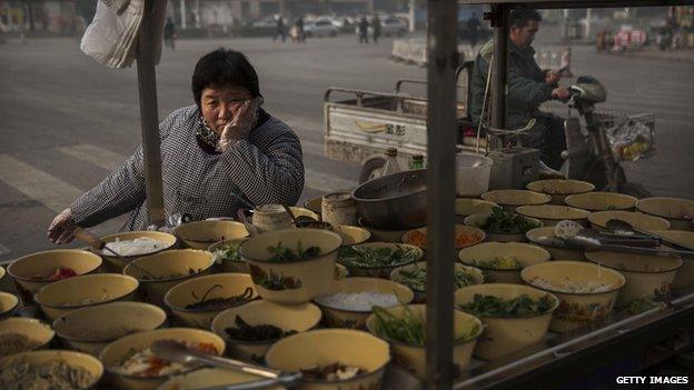 A Chinese food vendor waits for customers at a market in Hebei, just outside Beijing, China