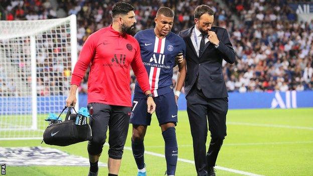 Kylian Mbappe hobbles from the field after getting injured playing for Paris St-Germain