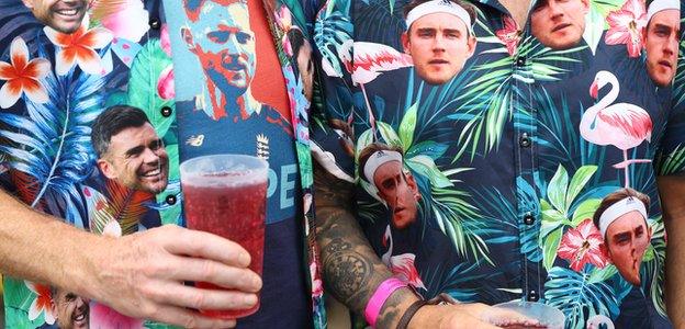 Fans stand in shirts bearing the face of Stuart Broad & James Anderson