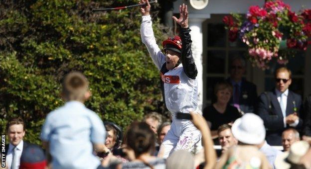 Frankie Dettori performs a flying dismount after winning at Sandown