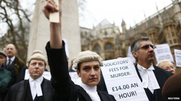 Barristers in their wigs and robes listen to speeches during a protest against cuts to the legal aid budget outside Parliament in central London, March 7, 2014