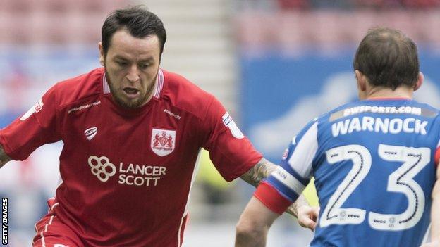 Lee Tomlin takes on Stephen Warnock of Wigan Athletic in March, 2017