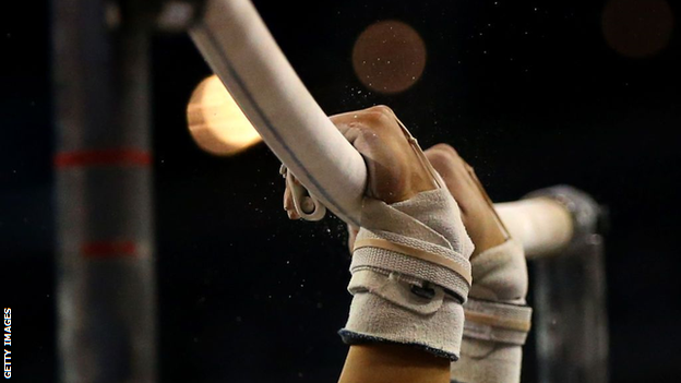 A gymnast's hands on the horizontal bars