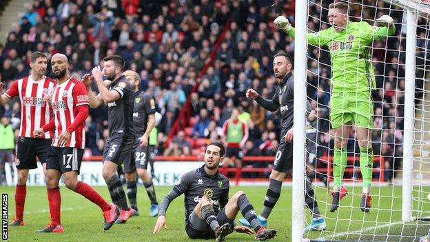 Dean Henderson celebrates after making a triple save against Norwich