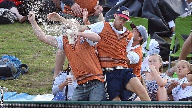 Cricket fans attempt to catch a six in the crowd