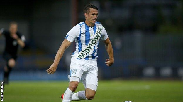 Jonathan Hogg wearing Huddersfield's new home kit with large logo of a bookmaker splashed across the front