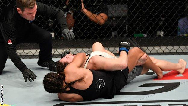 Julianna Pena secures a rear-naked choke submission against Sara McMann in January 2021