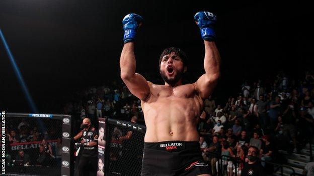 Tofiq Musayev celebrates on top of the cage