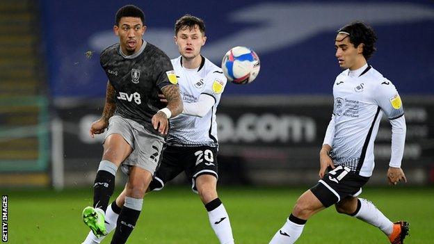 Wednesday's Liam Palmer clears under pressure from Swansea pair Liam Cullen and Yan Dhanda