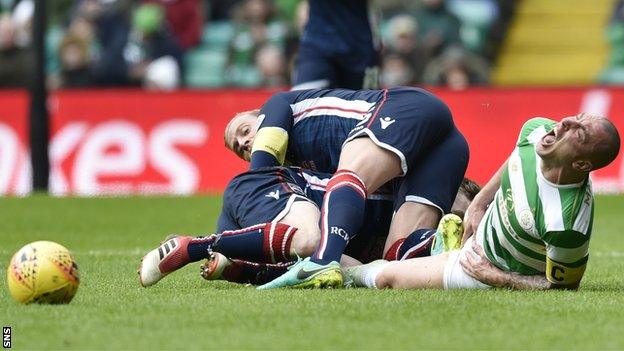 Andrew Davies looks back after fouling Scott Brown, who writhes in agony