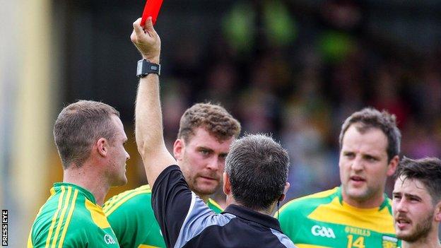 Referee Maurice Deegan red cards Neil McGee (left) in the game against Fermanagh