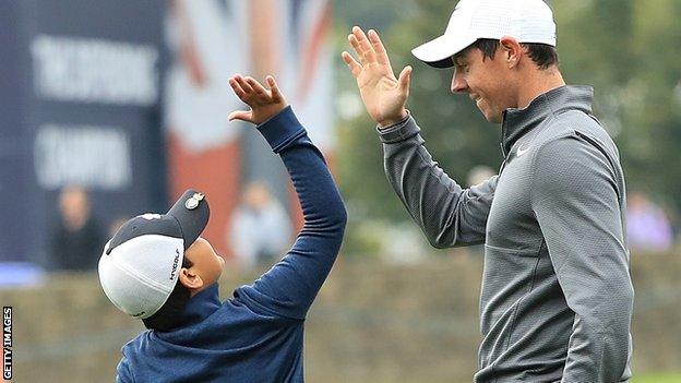 A young fan celebrates with Rory McIlroy after holing a putt in Wednesday's British Masters Pro-Am