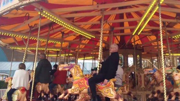 People on a vintage carousel at Dreamland