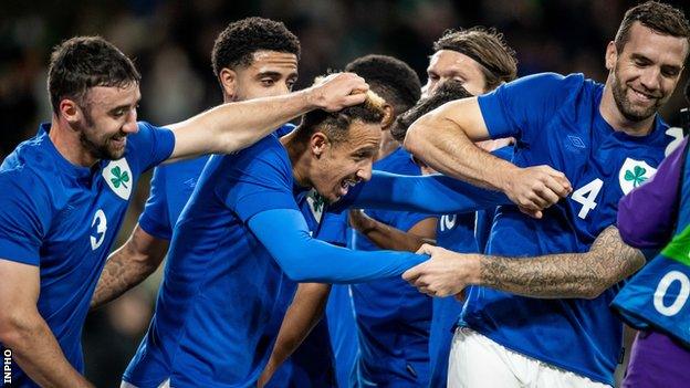 Callum Robinson is congratulated by his team-mates after netting his second goal against Qatar