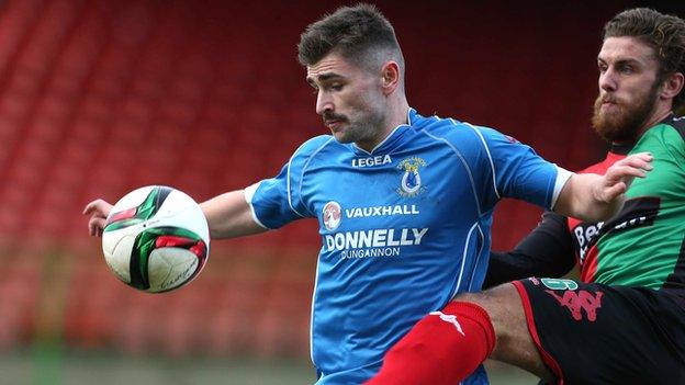 Dungannon's Cormac Burke battles with Glentoran's Stephen McCullough