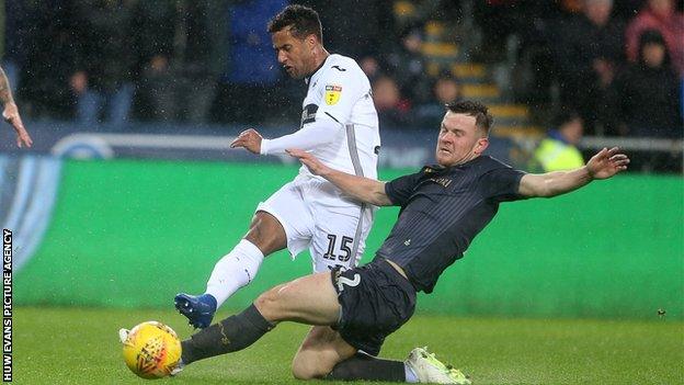 Swansea winger Wayne Routledge is challenegd by Jordan Thorniley of Sheffield Wednesday