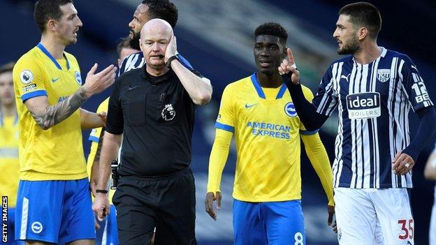 Brighton players with referee Lee Mason