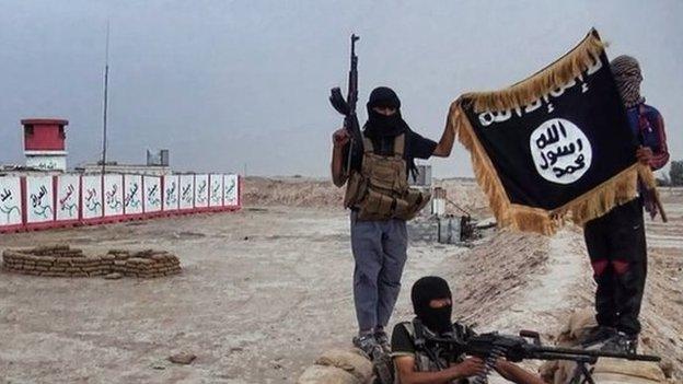 Militants of the Islamic State posing with the trademark Jihadists flag after they allegedly seized an Iraqi army checkpoint in the northern Iraqi province of Salahuddin