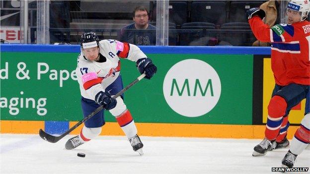 A GB ice hockey player plays the puck