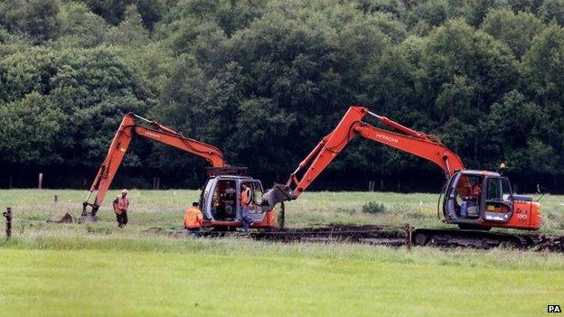 Members of the Independent Commission for the Location of Victims' Remains work at the scene